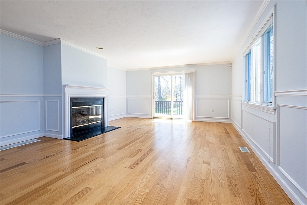 15 Beacon Court, Unit 229 Mashpee, MA 02649 - Photo 9 of 33 an empty room with wooden floor and fireplace