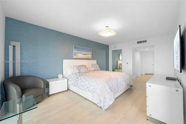 a bedroom with a bed couch and a view of kitchen