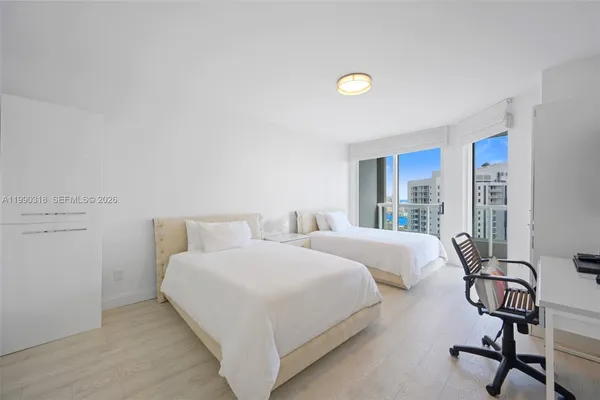 a bedroom with two beds and a window