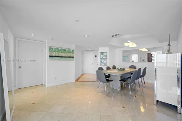 a dining room with furniture and a refrigerator