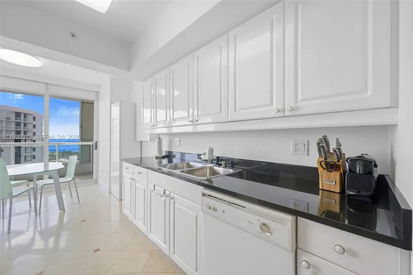 a kitchen with granite countertop white cabinets and sink