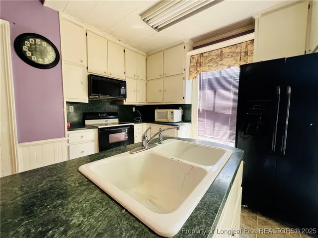 a kitchen with stainless steel appliances granite countertop a sink a stove a microwave and a refrigerator