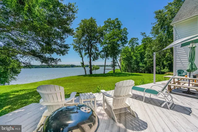 a view of a swimming pool and lounge chairs in back yard of the house