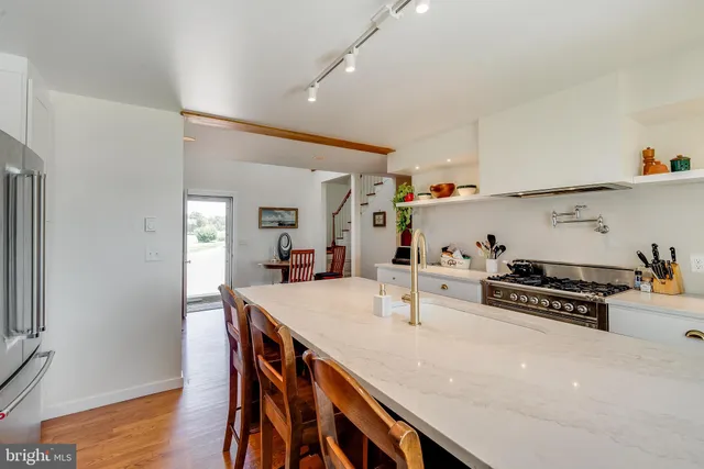 a kitchen with stainless steel appliances a sink a stove and wooden floor