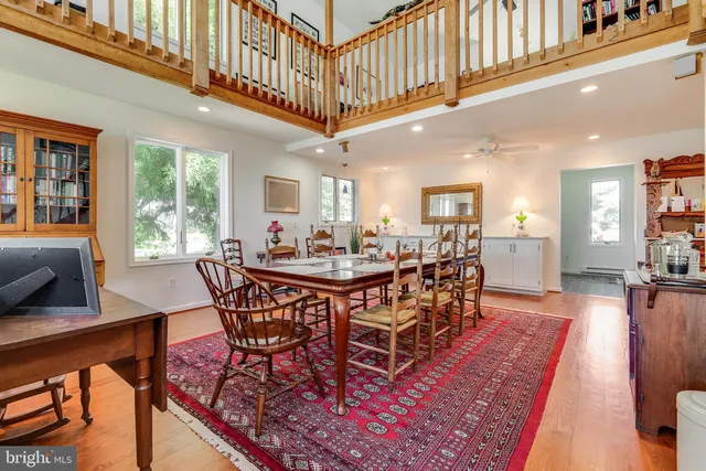 a dining room with wooden floor and large windows
