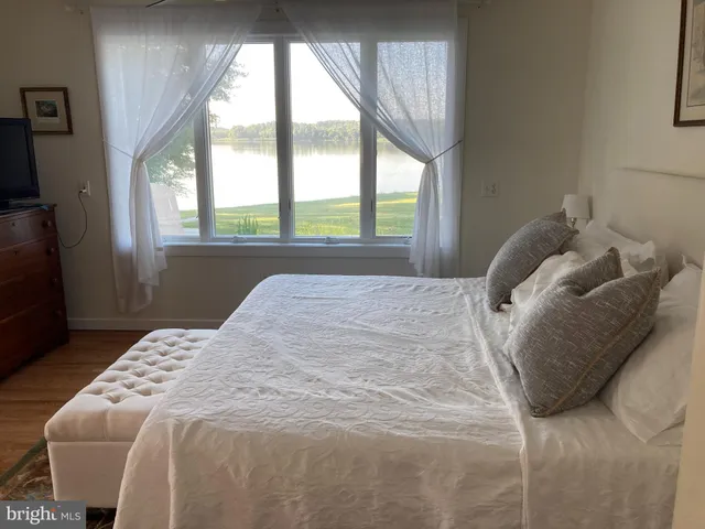 a bedroom with a bed and a large window