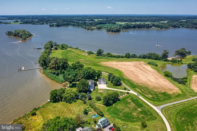 an aerial view of a residential houses with outdoor space and lake view