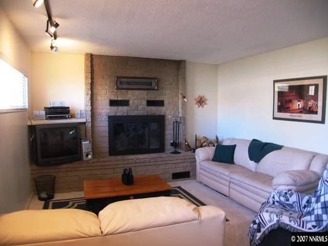3560 Downey Avenue Reno, NV 89503 - Photo 6 of 9 a living room with furniture a flat screen tv and a fireplace