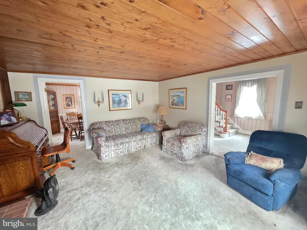 a dining room with wooden floor a chandelier a wooden table and chairs