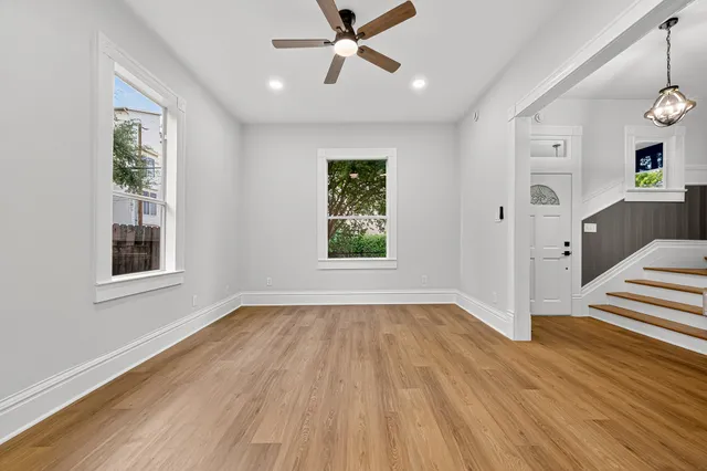 an empty room with windows and cabinet