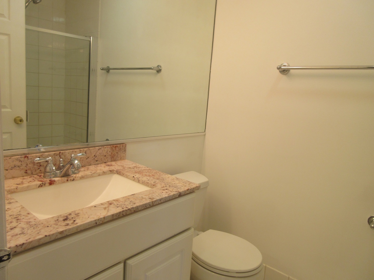 7255 North Ridge Boulevard, Unit 403 Chicago, IL 60645 - Photo 17 of 30 a bathroom with a granite countertop sink toilet and a mirror