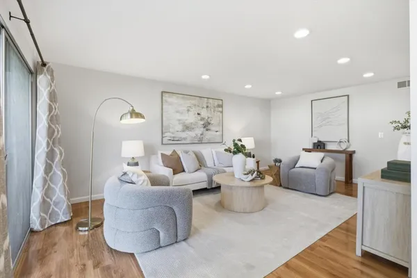 a living room with furniture and wooden floor