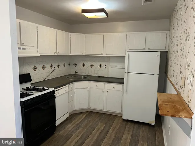 a kitchen with granite countertop white cabinets and white appliances