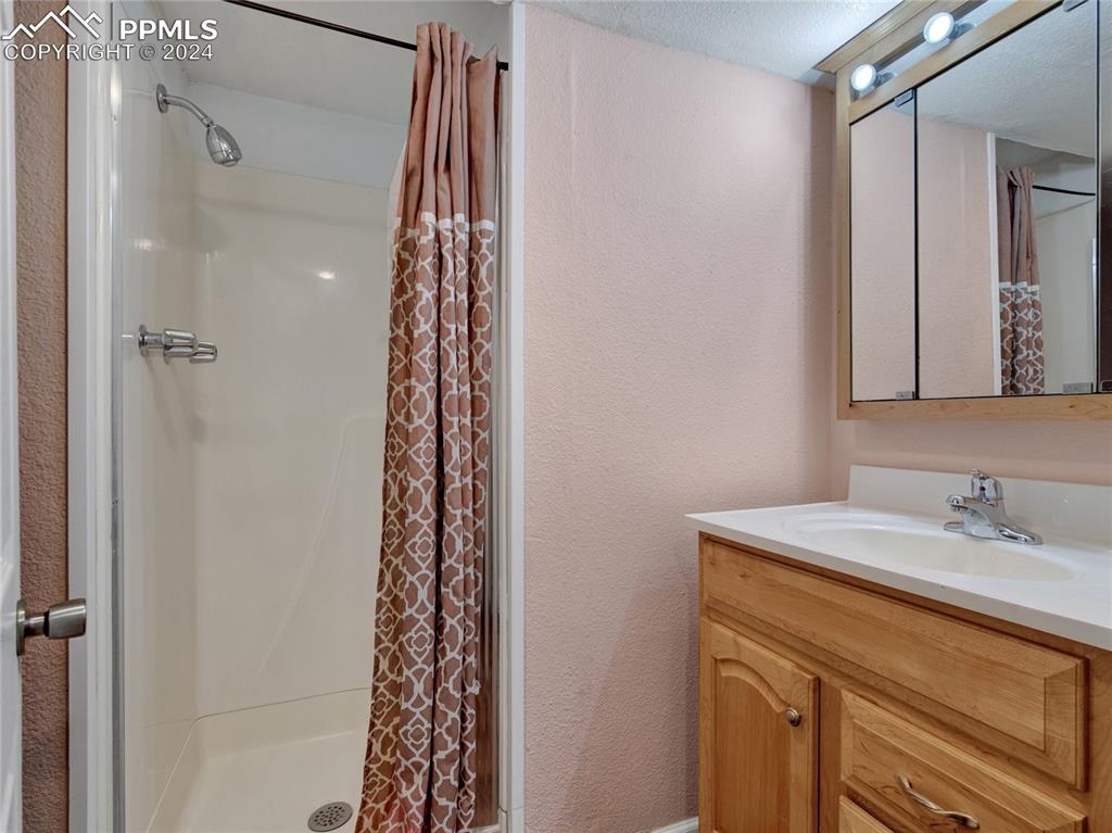 39 Duke Street Pueblo, CO 81005 - Photo 17 of 27 a bathroom with a sink a mirror a vanity and shower