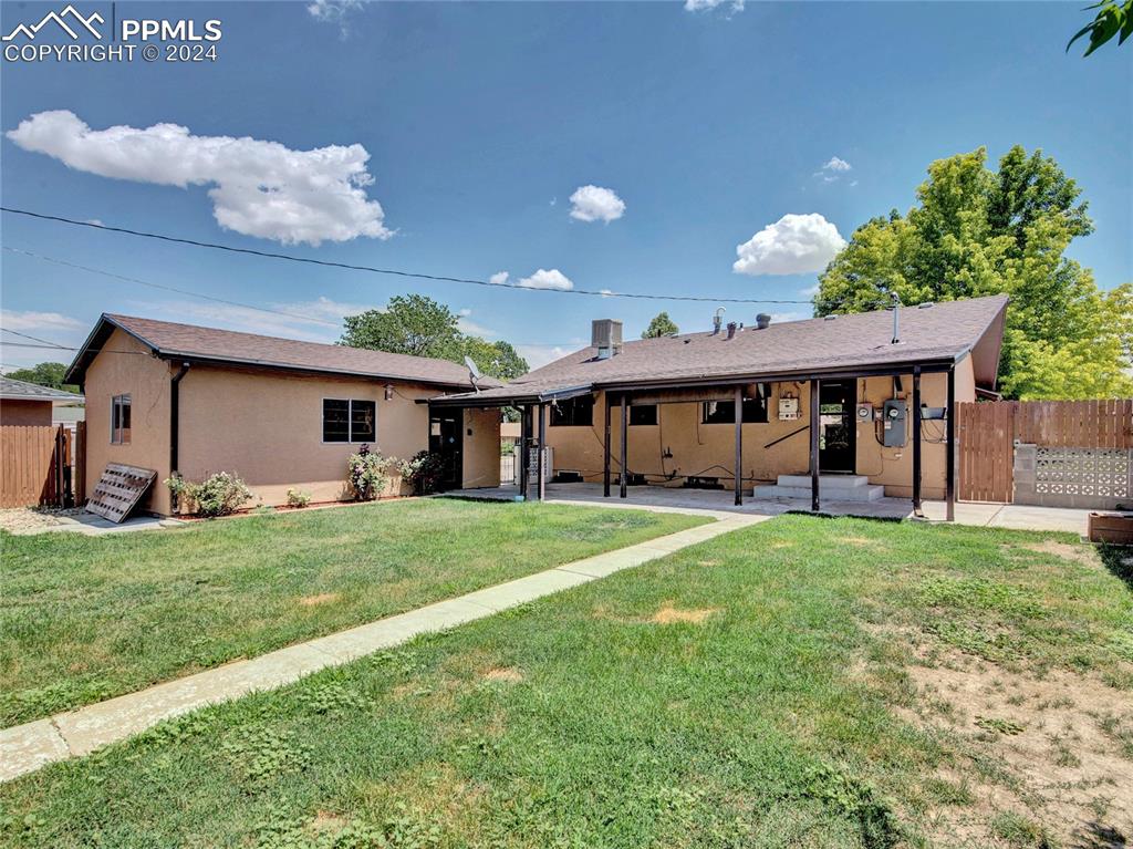 39 Duke Street Pueblo, CO 81005 - Photo 22 of 27 a view of a big house with a big yard potted plants and large tree
