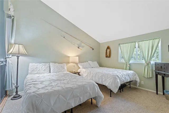 a bedroom with two beds and large window