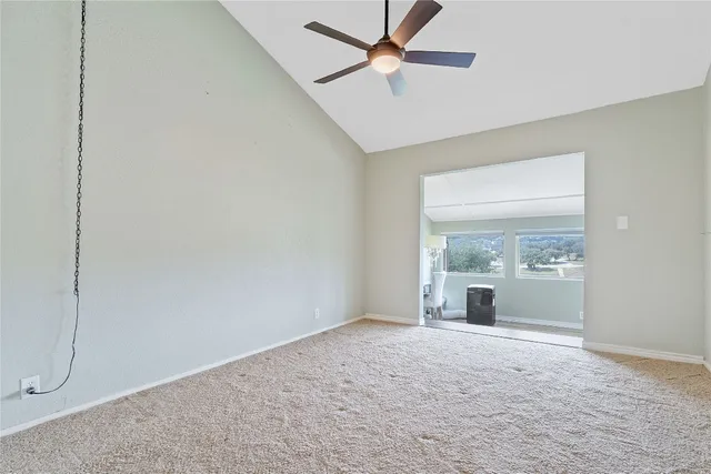 an empty room with a ceiling fan and a window