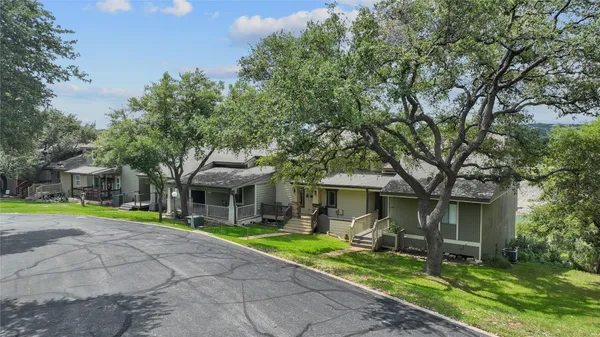 a front view of a house with a yard and trees