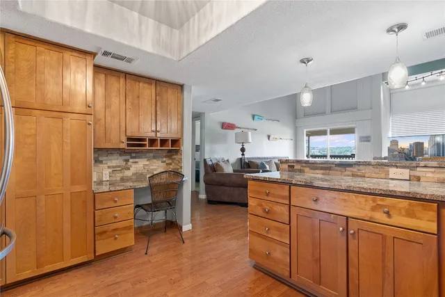 a kitchen with cabinets and wooden floor