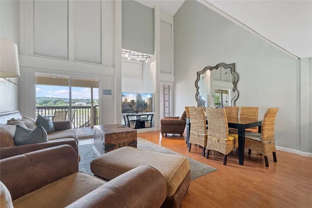 a living room with furniture a large window and wooden floor