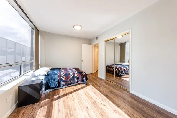 a bedroom with a bed and a large window