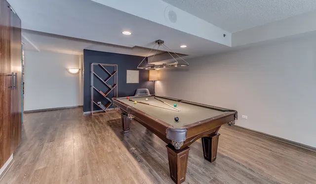 a room with wooden floors and pool table