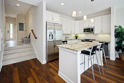 a kitchen with granite countertop a refrigerator and a stove top oven