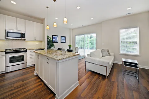 a kitchen with a sink wooden floor and stainless steel appliances