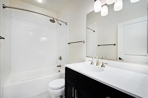 a bathroom with a sink a toilet a mirror and shower