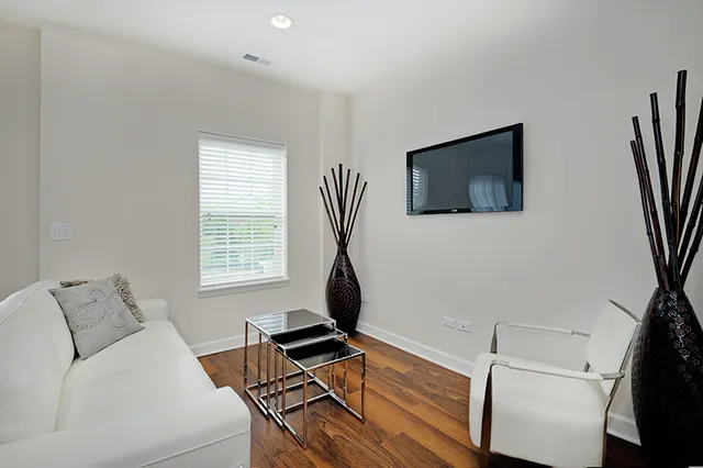 a living room with furniture a flat screen tv and a window