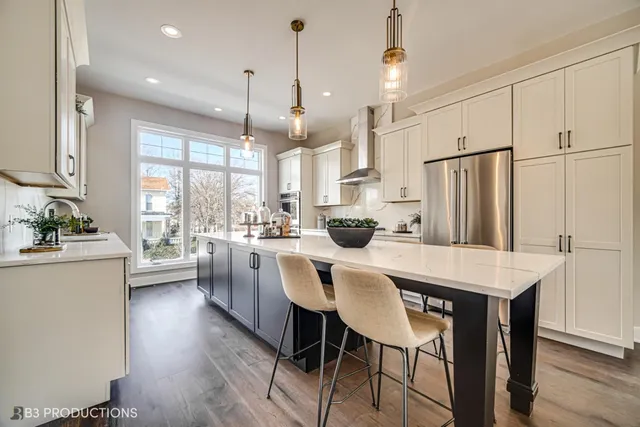 a kitchen with stainless steel appliances granite countertop a stove a refrigerator and a dining table with wooden cabinet