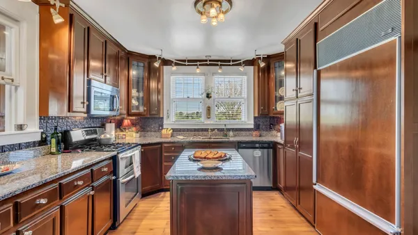 a kitchen with stainless steel appliances granite countertop a sink a stove and a refrigerator