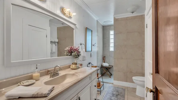 a bathroom with a granite countertop sink a toilet and a mirror