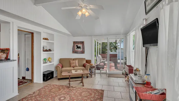 a living room with furniture a flat screen tv and a window
