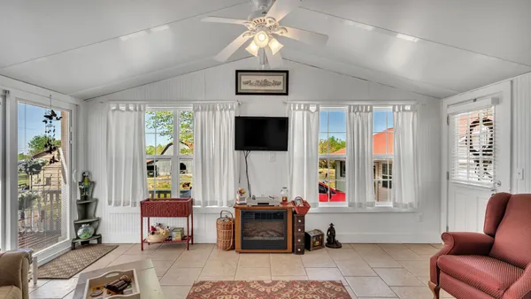 a living room with furniture a flat screen tv and a window