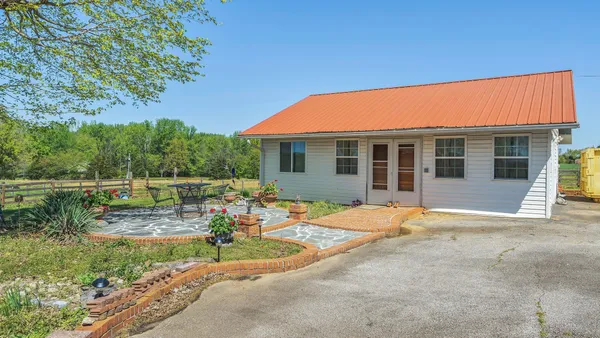 a backyard of a house with table and chairs