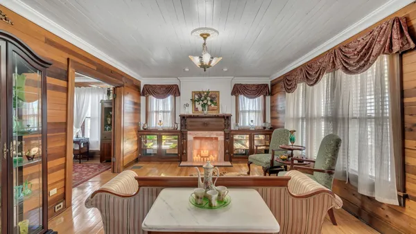 a living room with fireplace furniture and a large window