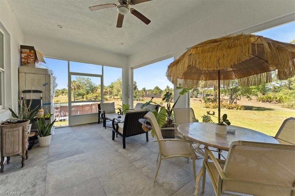 3219 64th Avenue Northeast Naples, FL 34120 - Photo 21 of 33 Sunroom / solarium featuring outdoor dining area, a hot tub, and ceiling fan
