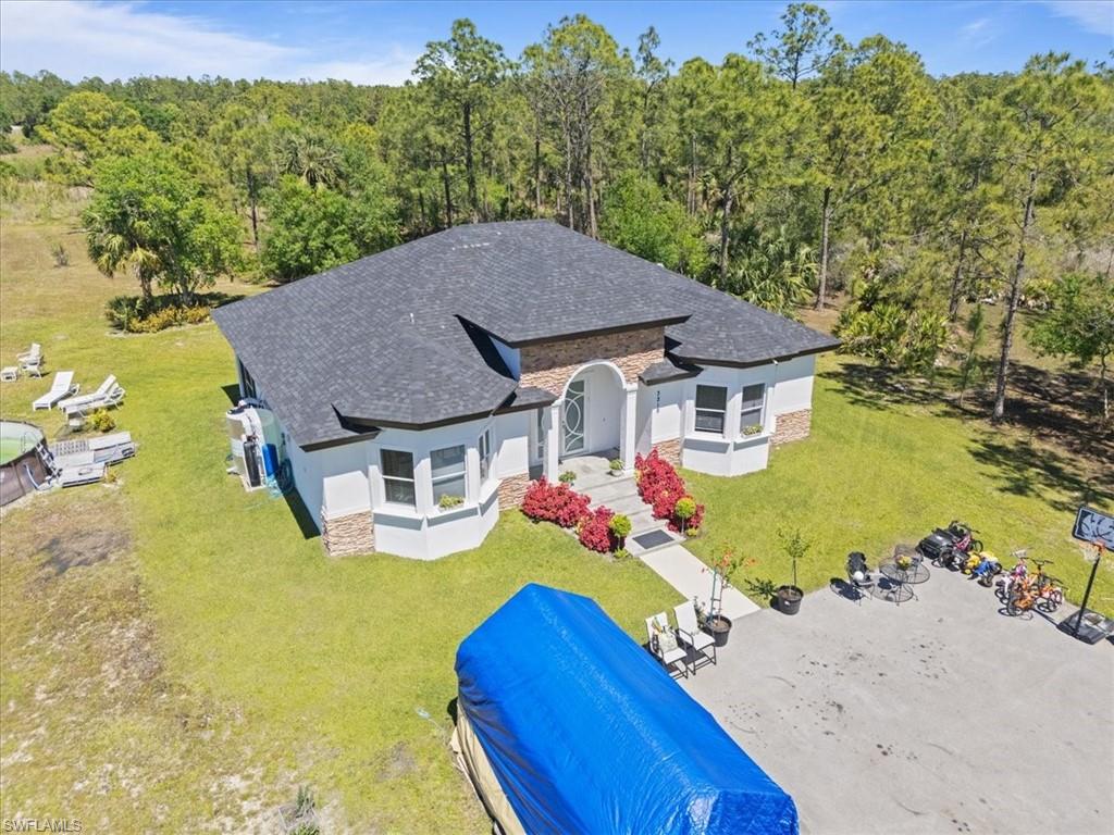 3219 64th Avenue Northeast Naples, FL 34120 - Photo 33 of 33 Birds eye view of property with a wooded view