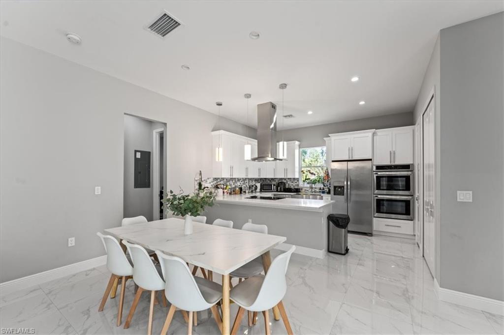 3219 64th Avenue Northeast Naples, FL 34120 - Photo 7 of 33 Dining space featuring visible vents, baseboards, electric panel, recessed lighting, and marble finish floor