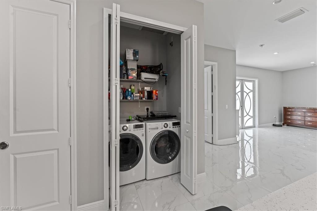 3219 64th Avenue Northeast Naples, FL 34120 - Photo 9 of 33 Laundry room with visible vents, baseboards, washing machine and dryer, laundry area, and marble finish floor