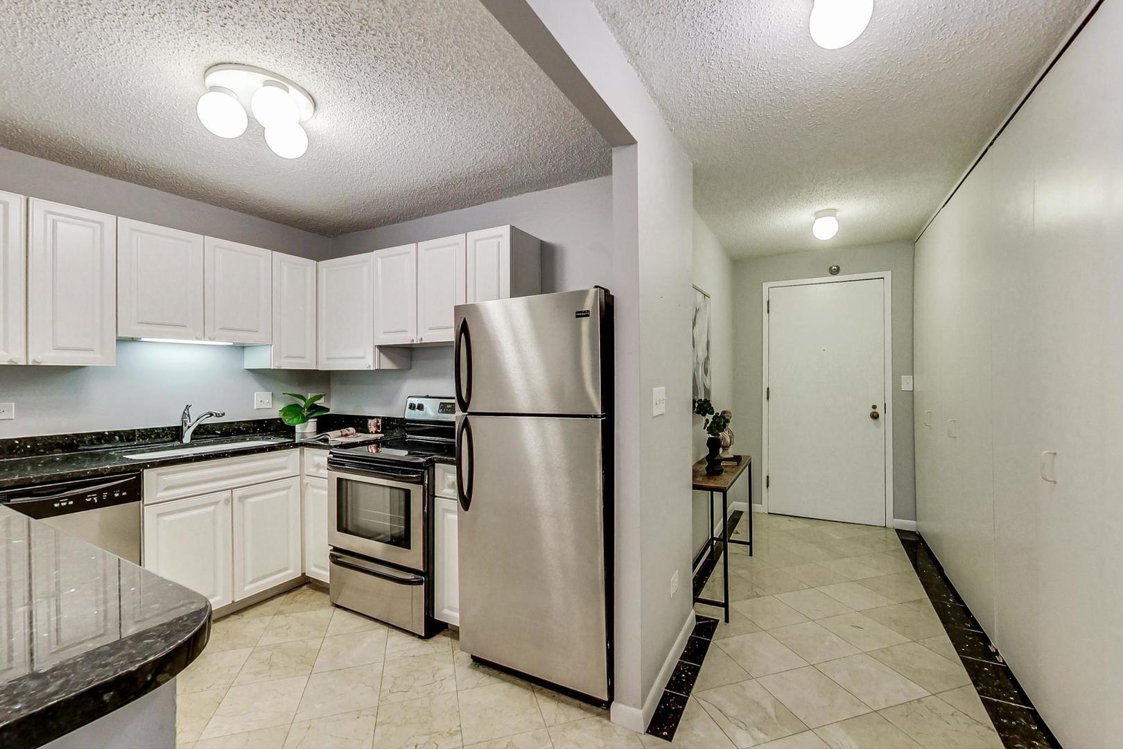 111 West Maple Street, Unit 3005 Chicago, IL 60610 - Photo 8 of 18 a kitchen with stainless steel appliances granite countertop a refrigerator and a stove