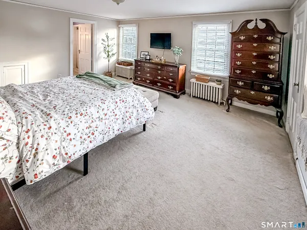 a bedroom with a bed dresser and a flat tv screen