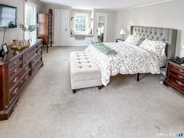 a bedroom with a bed couch and a window