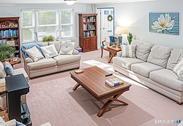 a living room with furniture a bookshelf and a window