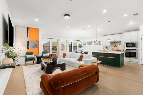 a living room with furniture kitchen and a large window