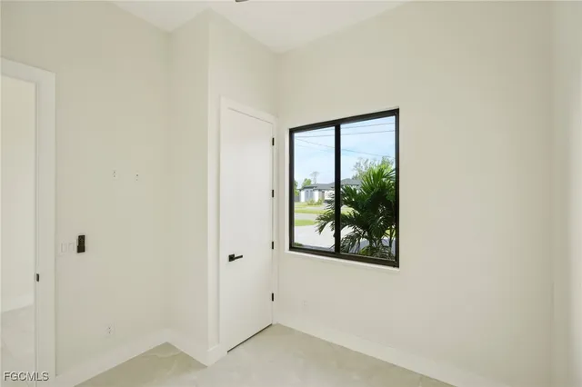 an empty room with a ceiling fan and a window