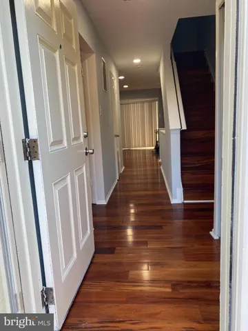 a view of a hallway with wooden floor and staircase