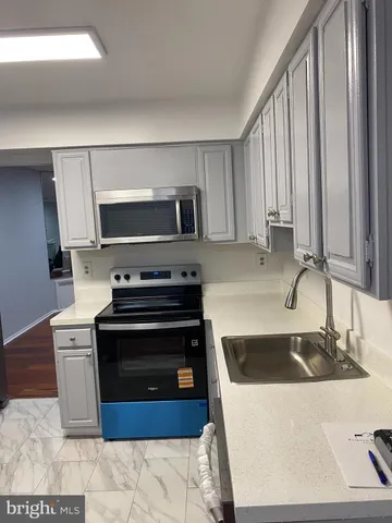 a kitchen with a stove a sink and a microwave