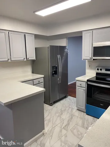a kitchen with stainless steel appliances a refrigerator stove and microwave